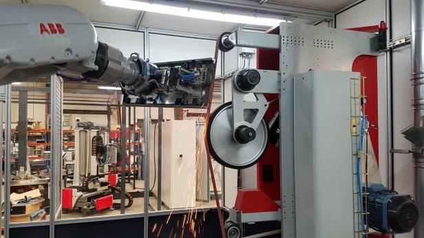 ROBOT CELL FOR THE WELD DRESSING, GRINDING AND SATIN-FINISHING OF PARTS (door covers) PREVIOUS TO CATAPHORESE